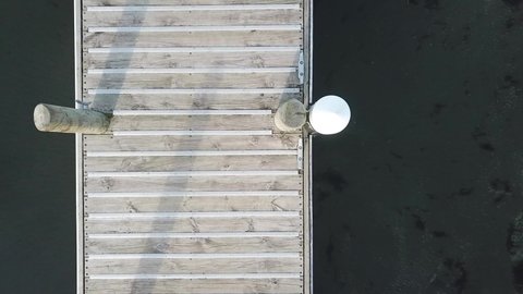 Aerial Top Down View, flying above Jetty slowly rising in Lake Taupo, tight angle to a wider angle.