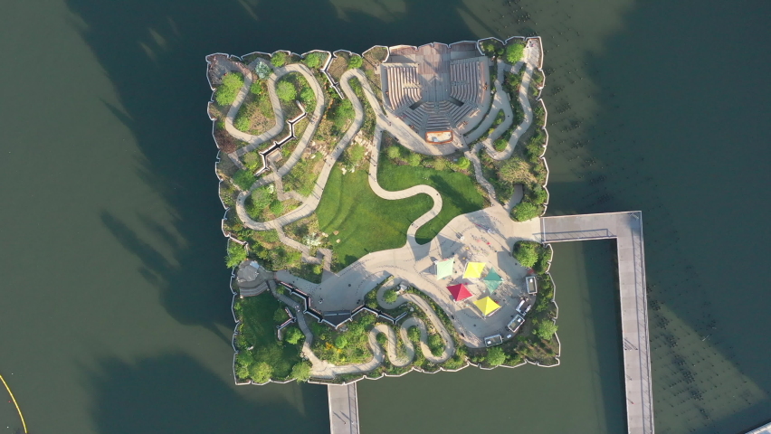 a top down shot directly above this Little Island in NYC on a sunny morning. The drone camera looking straight down, rotate counter clockwise over the floating.