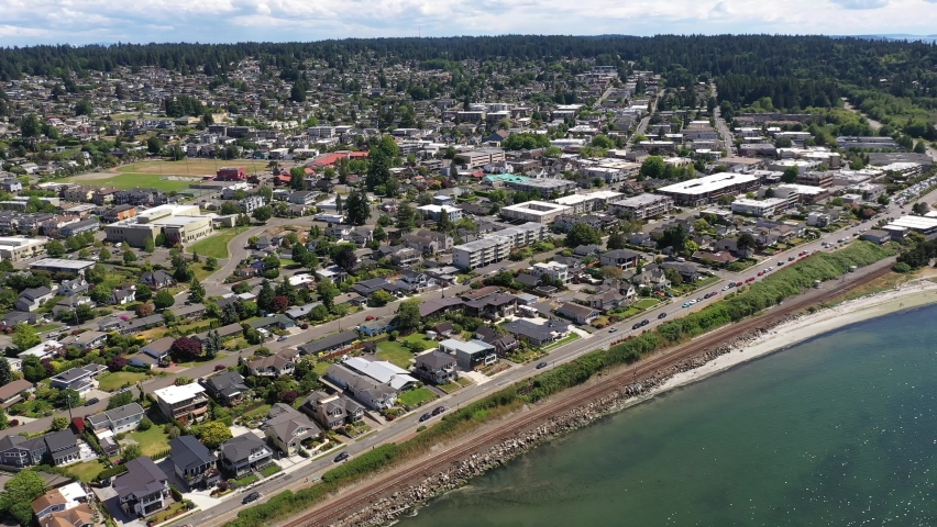 Cinematic 4K drone footage of the downtown Edmonds commercial area, Kingston ferry terminal waterfront marina, shoreline, Sunset beach near Seattle, Washington, Pacific Northwest, in Snohomish County