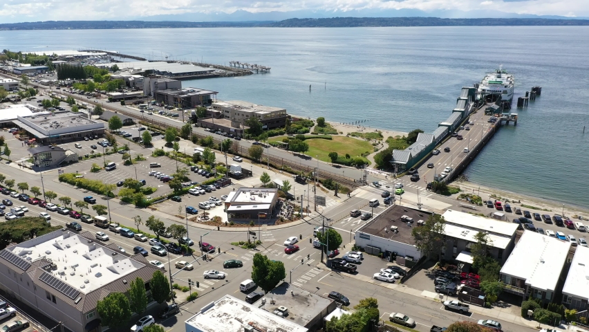 Cinematic 4K drone footage of the downtown Edmonds commercial area, loading Kingston ferry, terminal, waterfront marina, near Seattle in Washington, Pacific Northwest, in Snohomish County