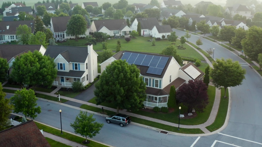 Rooftop solar panel array to generate renewable green energy. House in neighborhood in USA emission free energy generation. Royalty-Free Stock Footage #1075026770