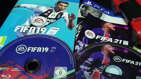 Rome, Italy - June 05, 2021, detail of the PS4 game DVD, Fifa 2019 and 2021, with an image of the footballer Cristiano Ronaldo, Kylian Mbappé and a detail of the red controller.