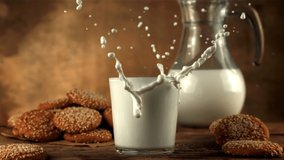 Super slow motion oatmeal cookies falls into a glass of milk with spray. On a brown background.Filmed on a high-speed camera at 1000 fps. - Powered by Shutterstock - Get 15% off with code: PIKWIZARD15