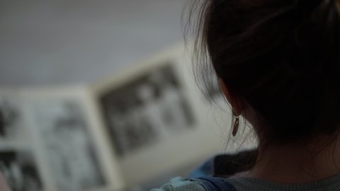 Woman looking at old photo album of her family.