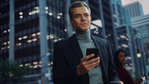 Portrait of Handsome Young Adult Businessman Using Smartphone on the Street in a Big City. Confident Executive Connecting with People Online, Messaging, Browsing Internet on His Way to Office.