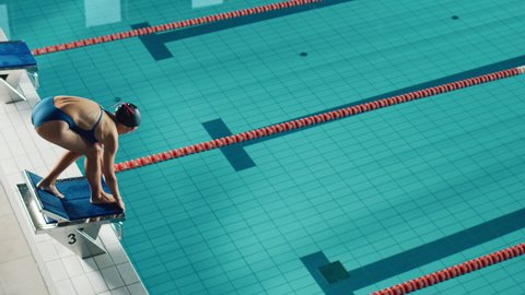 Beautiful Female Swimmer Diving in Swimming Pool. Professional Athlete Determined to Win Championship, Front Crawl, Freestyle. Cinematic Slow Motion Shot with Stylish Colors, Artistic High Angle