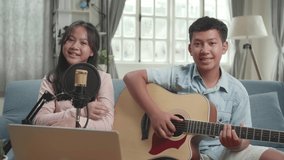 Asian Boy With Guitar And Girl Smiling. The Children Is Broadcasting Live On The Internet
