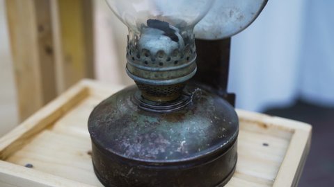 Old rusty kerosene lamp. Retro lamp with a mirror plate for reflection of light and heat. Close-up of the legs of a gasoline lamp