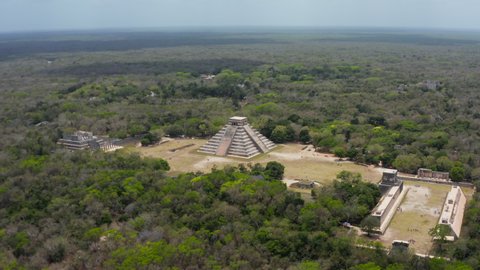 Aerial footage of Temple of Kukulcan - El Castillo. Tourist attraction inside Yucatan rain forest. Historical monuments of pre-Columbian era, Chichen Itza, Mexico.