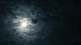 Time lapse night clouds running in front of spooky full moon