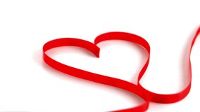 Animation of red ribbon in heart shape with red heart confetti falling, over network on white. valentine's day, love, communication and romance concept digitally generated video.
