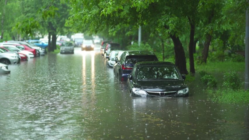 Flooded cars on the street of the city. Street after heavy rain. Water could enter the engine, transmission parts or other places. Disaster Motor Vehicle Insurance Claim Themed. Severe weather concept Royalty-Free Stock Footage #1075062050