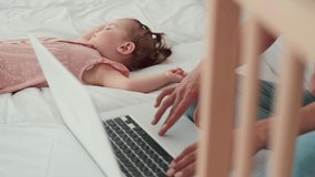 Using ChatGPT.Chat GPT.Artificial Intelligence.Childcare at Home, Child Protection, New Life, Leisure with Baby. Busy mom works using laptop while baby is sleeping next to her.