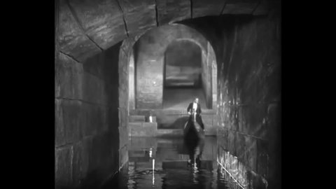 CIRCA 1925 - The phantom (Lon Chaney) drowns someone riding in a boat through his underground tunnels while Raoul tries to rescue Christine.