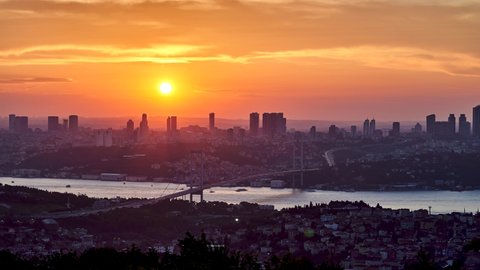 Sun is setting down behind skyscrapers and Bosphorus Bridge (15 Temmuz Bridge). Sunset panorama timelapse, Istanbul, Turkey. Faster version
