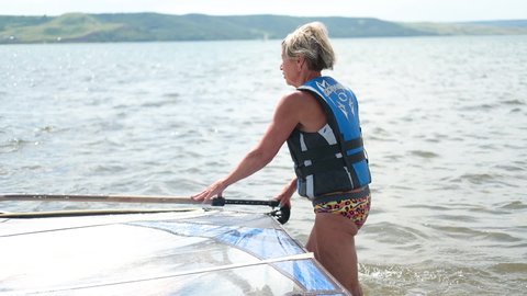 Ufa, Russia, June, 13, 2021, senior woman life jacket with windsurfing
