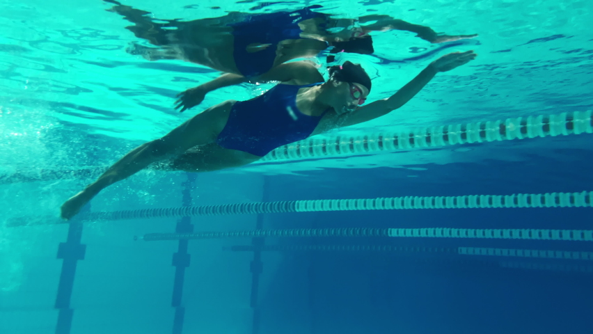 Underwater Shot: Fit Beautiful Swimmer doing Laps in Swimming Pool. Professional Female Athlete swims at Great Speed. Ready To Set World Championship Record. Colorful Artistic Stylish Tracking Shot | Shutterstock HD Video #1075109711