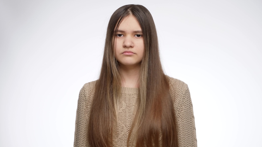 Studio portrait of displeased girl shaking head and saying no. Denial sign