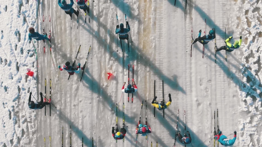 Many people on ski race competition in covered snow winter forest. Aerial view. cross-country skiing