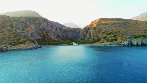 Establishing Shot of Preveli Beach. Nature Aerial Scenery of Mountain Canyon or Gorge with River and Palms in Crete, Greece. Greek Landmark as Touristic Vacation Travel Destination. 4K Drone Shot
