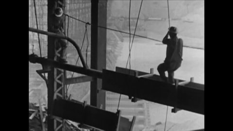 CIRCA 1930s - Construction workers use pulleys to haul steel beams to their perch in the Midwest.