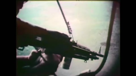 CIRCA 1960s - American soldiers fire guns from helicopters over Vietnam while foot soldiers ford rivers and muddy ground.