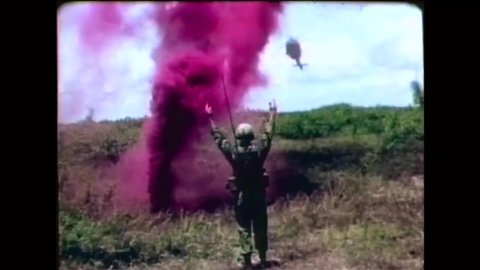 CIRCA 1960s - American soldiers signal a helicopter with colored smoke and servicemen board it and fly off in Vietnam.