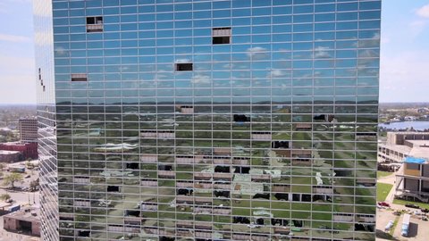 IOWA - CIRCA 2020s - Aerial drone footage mirrored glass high rise office building with storm, high wind damage and broken windows in Iowa.