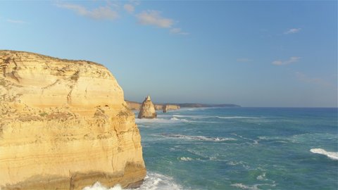 AERIAL: Picturesque drone point of view of the limestone formations at the coast of Victoria. Flying along the 12 Apostles shore on a sunny summer day in Australia. Cliffs and promontories in Oceania.