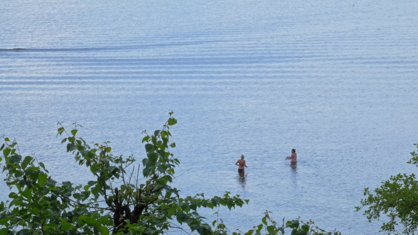 Female Vacationists Swimming On Calm Lake Near Styporc Village In Northern Poland. - Static Shot