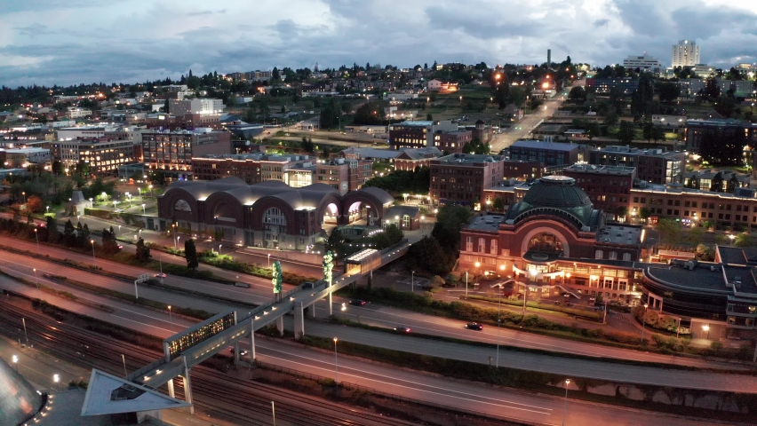 Cinematic 4K sunset evening night aerial drone shot of the Tacoma downtown waterfront, old town, business district, Dock Street Marina, Glass Museum, yachts and sailboats in Tacoma, Washington