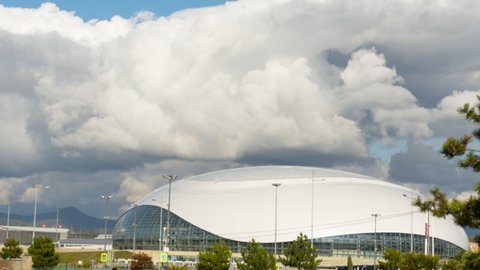 SOCHI, RUSSIAN FEDERATION - NOVEMBER 17, 2020: Dark dramatic rain clouds flying, passing, flowing, floating sky time lapse. Storm rain weather clouds flying sky. View of the Bolshoy Ice Dome in the