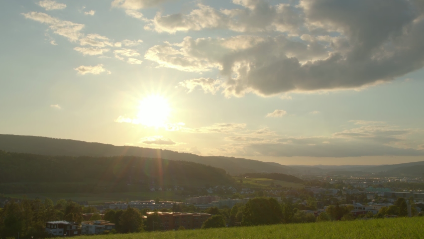Time lapse Sunset. Clouds with sunbeams over the hills. Switzerland.