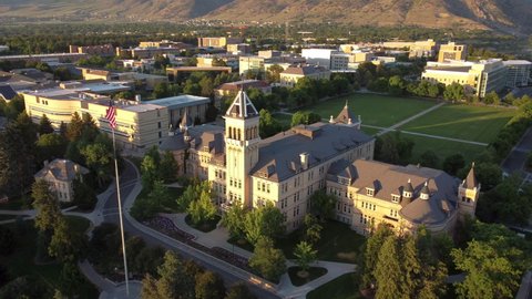 Logan, Utah - June 14, 2021: Utah State University (USU) Old Main Building with American Flag and Quad