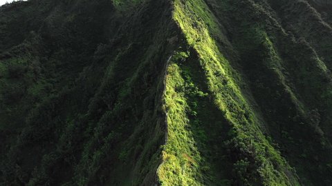 Aerial Moving Towards Hikers On A Mountain Ridge Hiking Trail Stairway, With Rough Terrain And Lush Green Slopes - Oahu, Hawaii