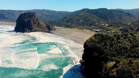 Aerial overview of famous New Zealand Piha Beach and holiday village