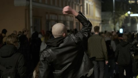 Moscow, 21.04.21 - Bald skinhead football hooligan fan marching among political rally in Defense of Alexey Navalny. Provocative behavior foot ball team supporter looks like fascism aliened skin head.