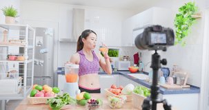 Asian Fitness woman records training on juice and salad cooking - Distances diet through camera video tutorial