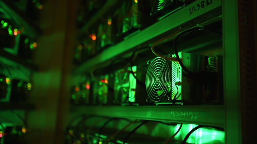 Bitcoin miners in large farm. ASIC mining equipment on stand racks mine cryptocurrency in steel container. Blockchain technology application specific integrated circuit datacenter. Server room lights. Royalty-Free Stock Footage #1075173782
