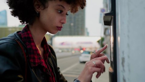 Young woman using payment machine in the city