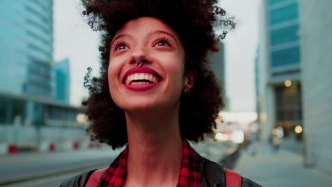Young beautiful woman looking up smiling brightly