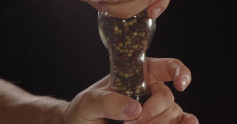 Similar spices on a black background in hand. Pepper mixture