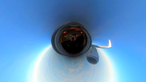 Airplane window. Wide angle. 360 degrees. The guy on the plane, the young man with glasses in a medical protective sterile mask on his face. View of the mountains and clouds. Milan, Italy, July 2021: