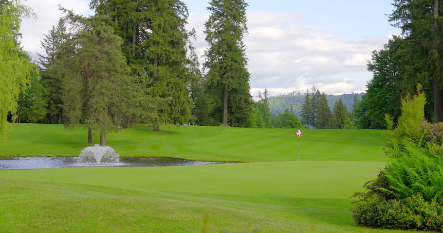 Establishing shot of golf course with gorgeous green and forest view in Vancouver, Canada, North America. Day time on May 2021. Still camera. ProRes 422 HQ. Royalty-Free Stock Footage #1075194602