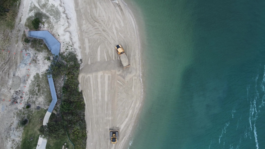 Unique view of large machinery working on a environmentally sensitive coastal rejuvenation project. High drone view looking down. Royalty-Free Stock Footage #1075205501