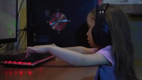 Baby girl playing online video game at home at night. The problem of dependence on computer games in children