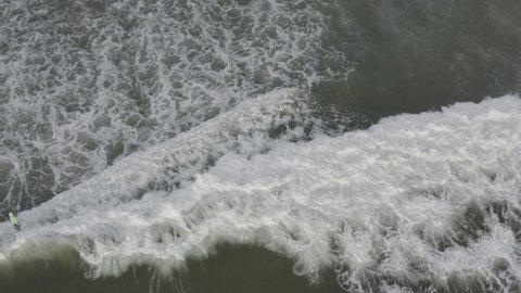 Ocean waves wash sand beach. Aerial Cinematic drone shot. Surfers Paradise, Gold Coast. Seascape in Queensland Australia.  10-bit Dlog-M.