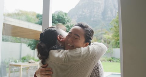 Happy asian mother embracing adult daughter arriving at backdoor. happy family spending quality time at home together.