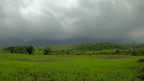 landscape of lush green and mountain range with moving clouds during monsoon in India