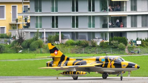 Mollis Switzerland AUGUST, 16, 2019 Military training jet airplane painted as a tiger lines up on the runway to take off. Hawker Hunter two seats jet fighter aircraft of Swiss Air Force